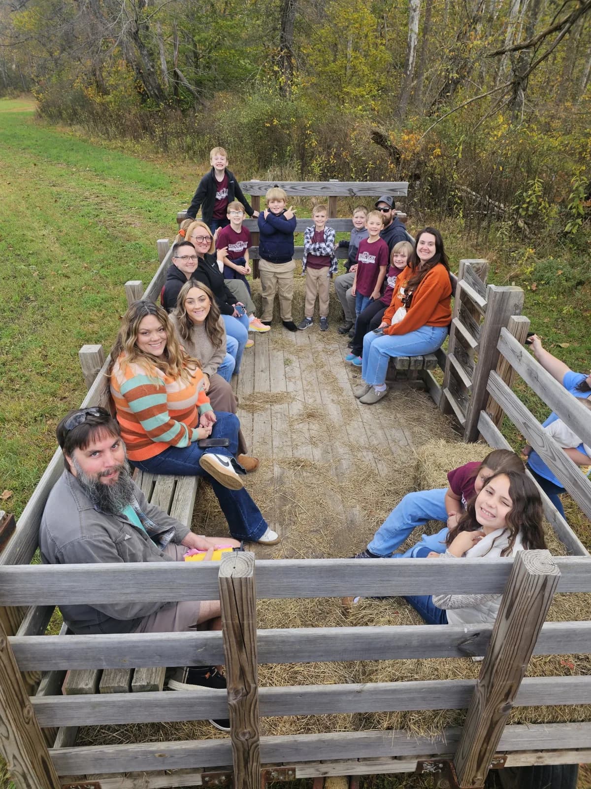 Students and families enjoying a hayride during a fall field trip