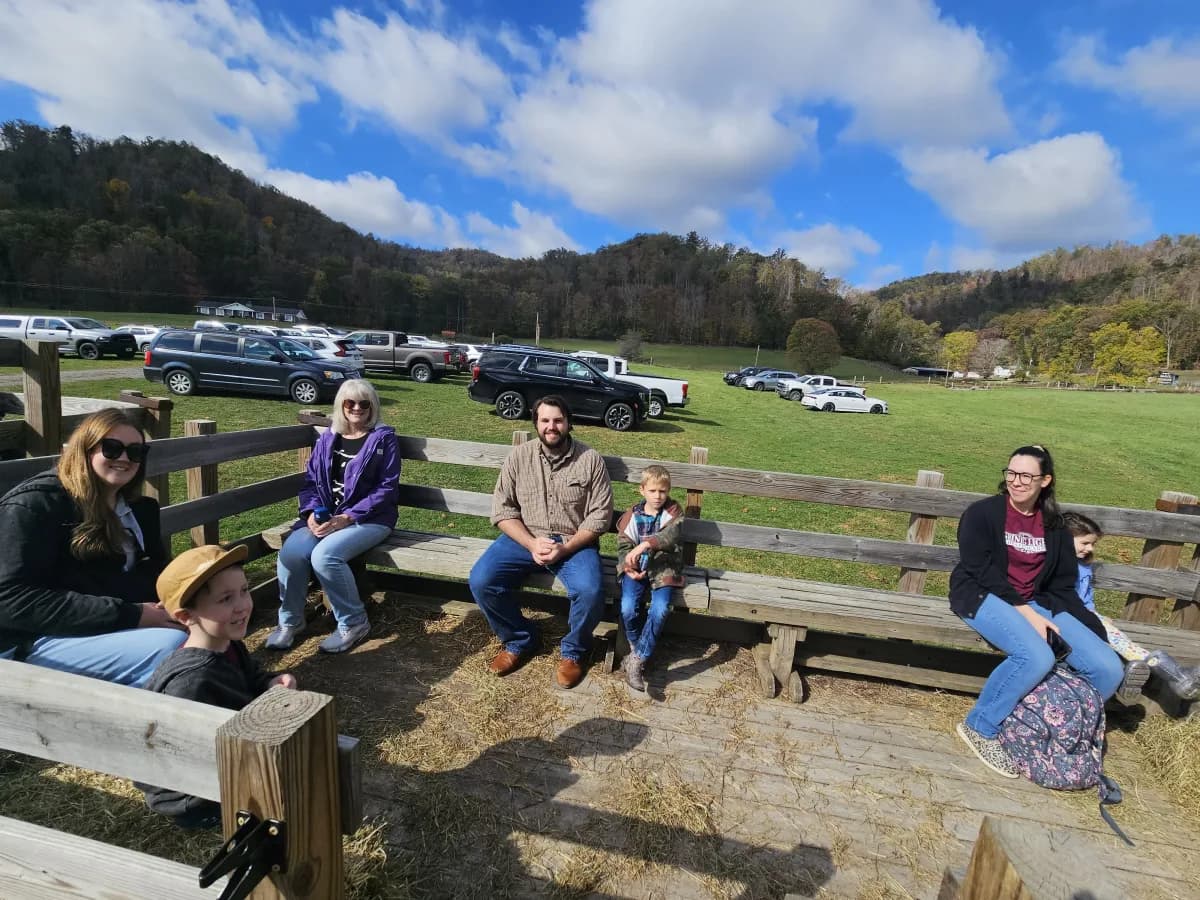 Parents and families sitting on hay bales during the fall field trip