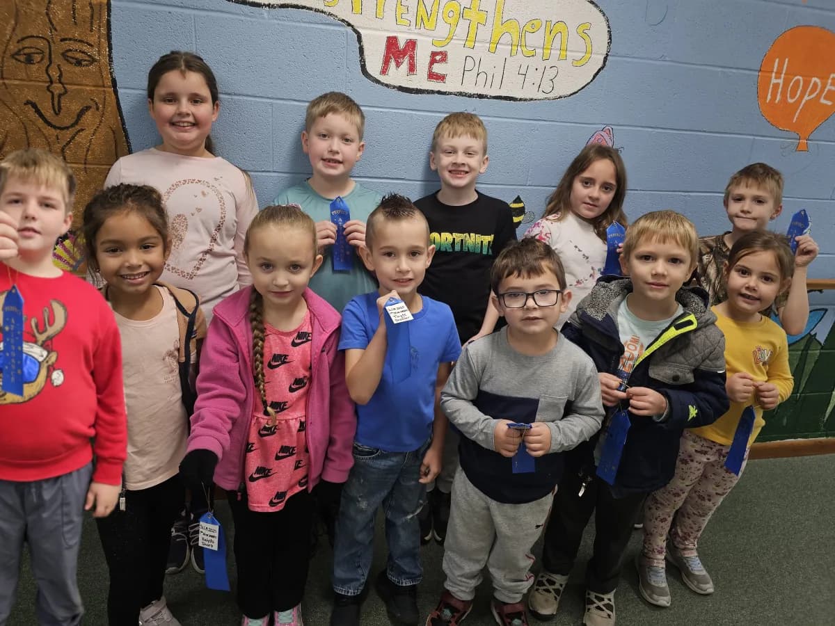 Students standing together in front of a bulletin board with Bible verse display