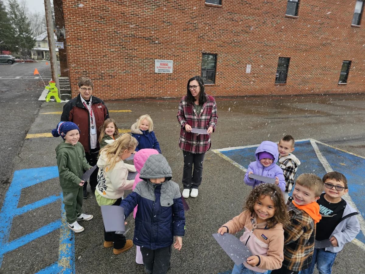 Students and teacher gathered outside in the parking lot on a winter day