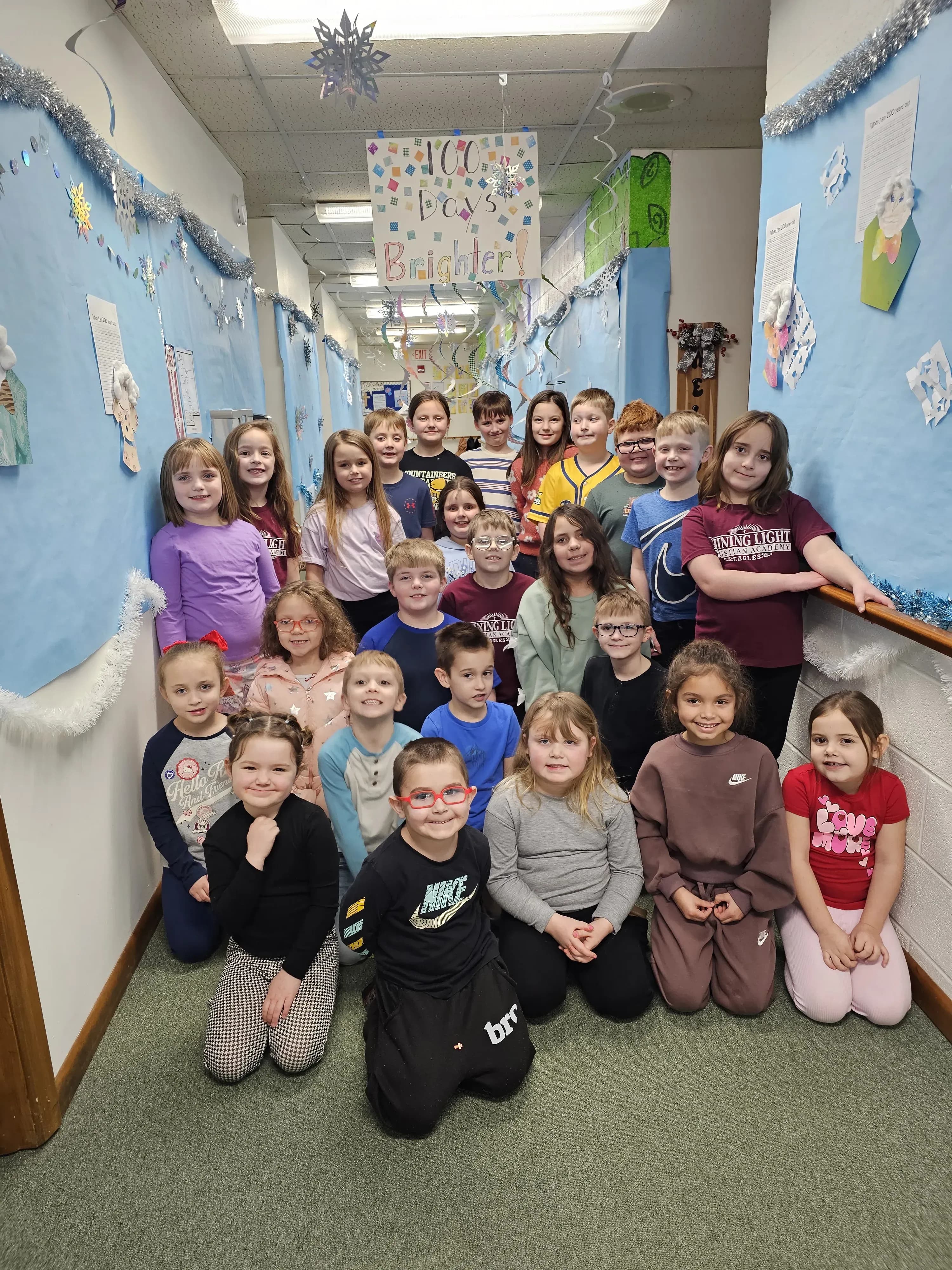All students gathered for a winter group photo in the classroom with snowflake decorations